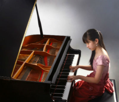 Asian piano student performing on grand piano